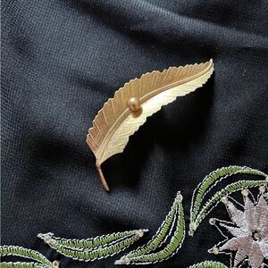 VTG Gold tone metal feather brooch with clasp closure. Unsigned